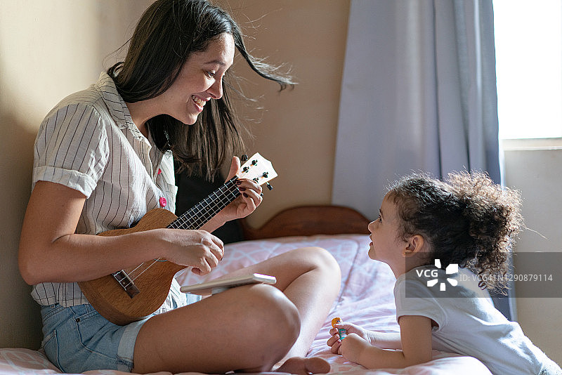 阿姨为侄女弹奏尤克里里图片素材