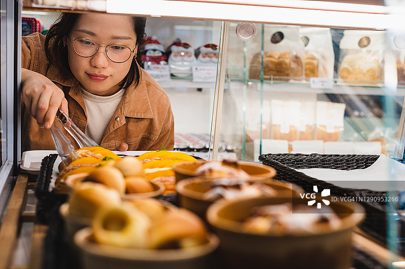 亚洲女性在面包店购物图片素材
