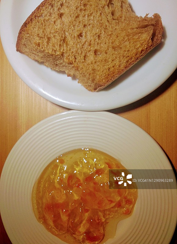 早餐。棕色面包和橘子酱盘图片素材