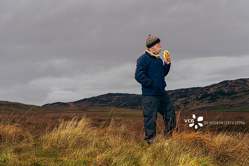 老年男子在苏格兰西南部阴沉的冬日里，在偏远地区休息图片素材