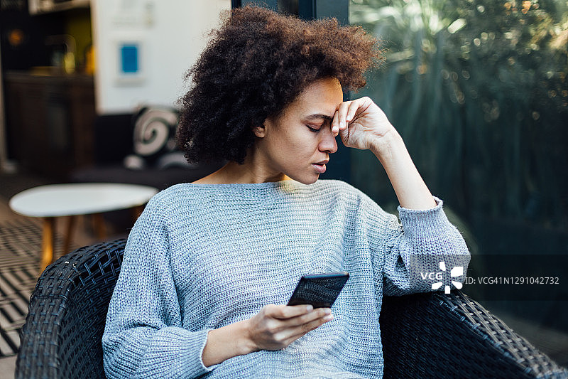 年轻的非裔美国女性在移动设备上阅读坏消息图片素材