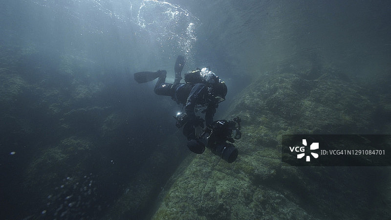 水肺潜水员携带影视设备潜入海中图片素材