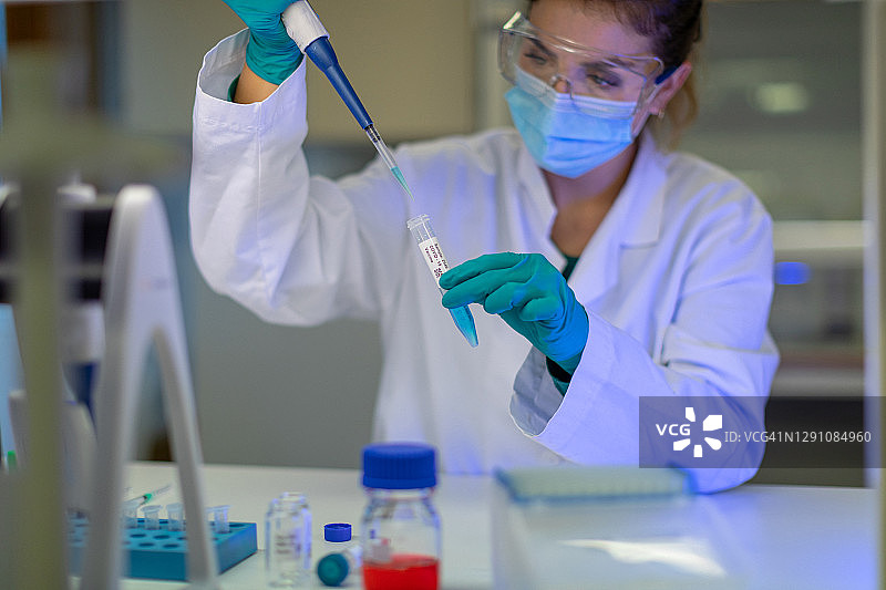 女研究员在实验室工作：研究新冠病毒疫苗图片素材