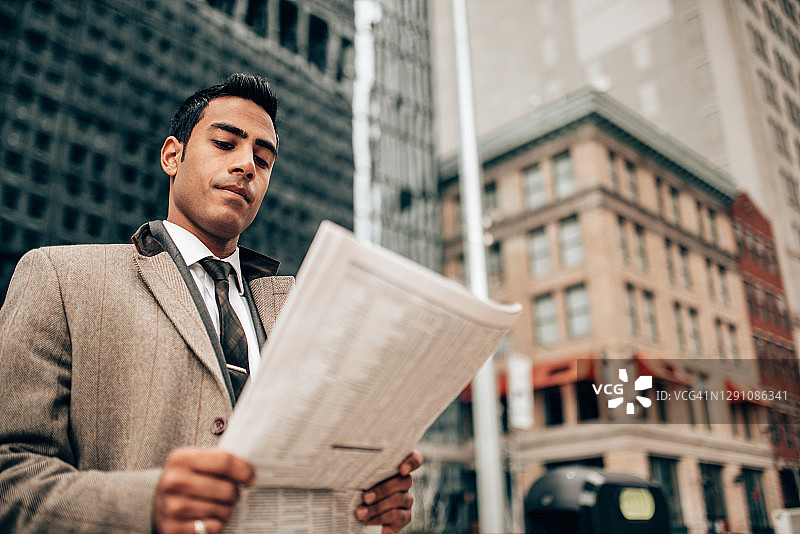 在曼哈顿读报纸的印度商人图片素材