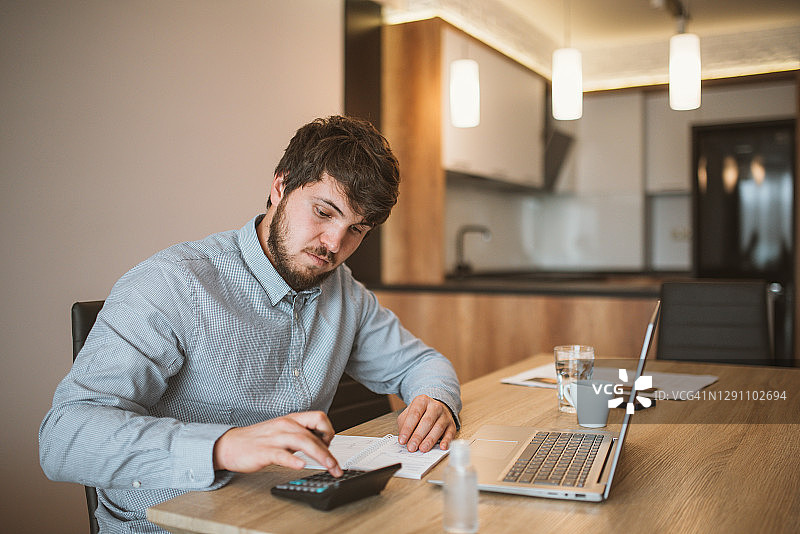 疫情期间计算损失的年轻商人图片素材