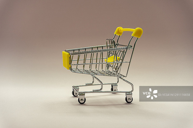 柔和粉色背景上的购物手推车图片素材