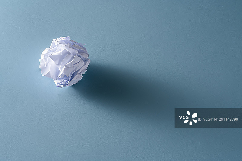 蓝色背景上的皱纸团图片素材