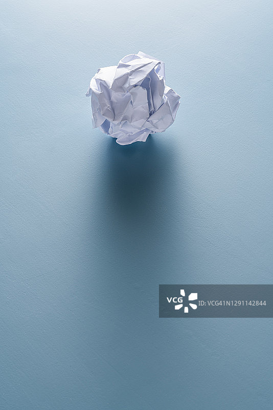 蓝色背景上的皱纸团图片素材