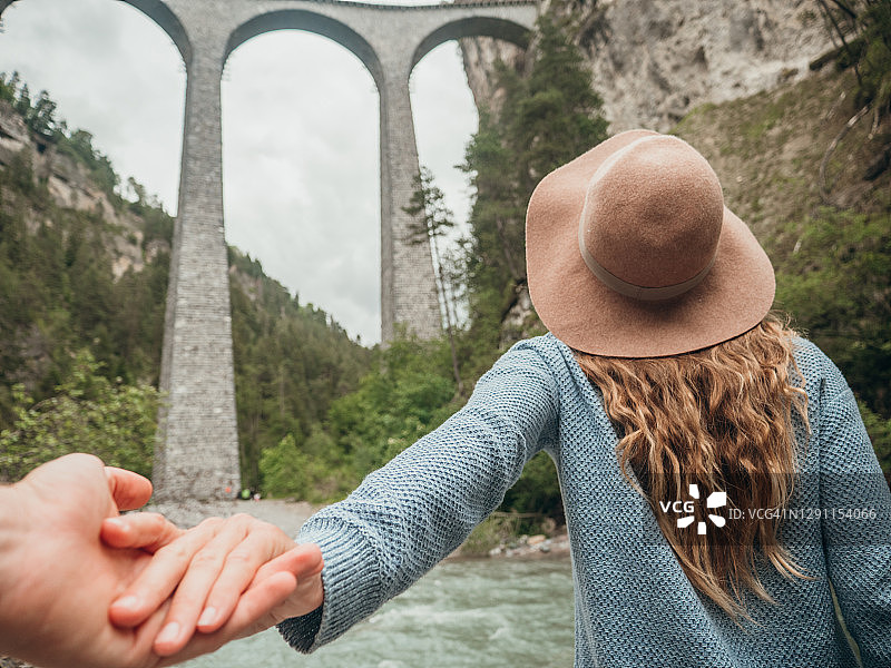 情侣在著名高架桥附近牵手，女子带路图片素材
