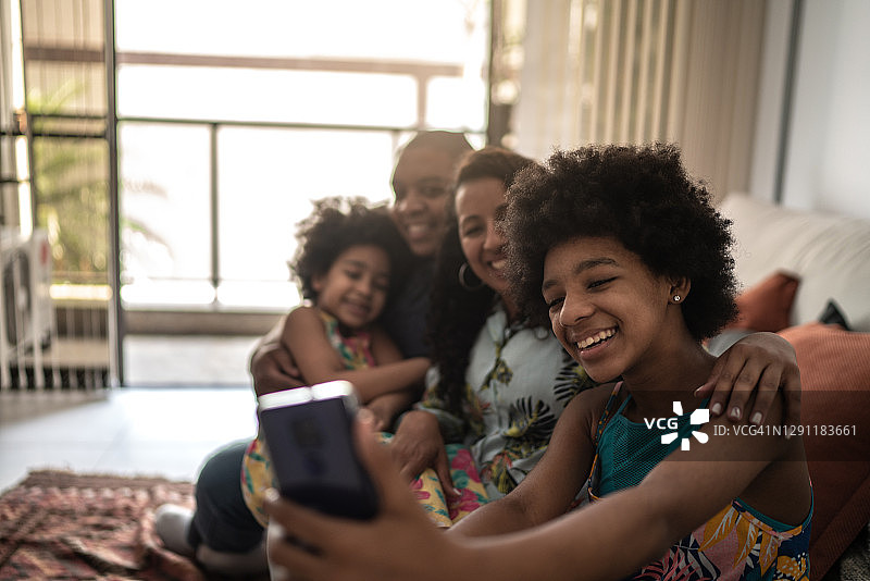 少女在家中客厅与家人自拍或进行视频通话图片素材