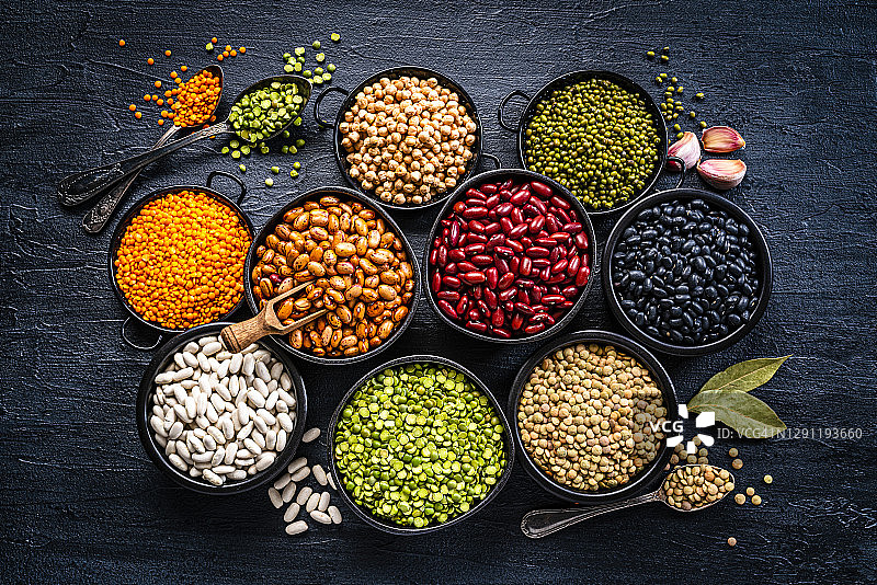 深色桌面上方拍摄的各种干豆和豆类图片素材