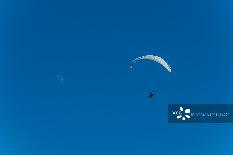 靠近月亮的滑翔伞图片素材