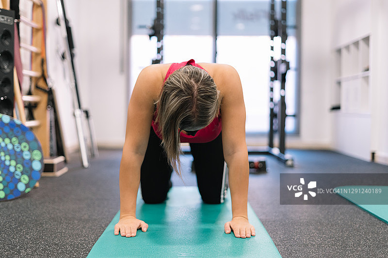 在健身房戴着面罩做平板支撑的金发女人图片素材