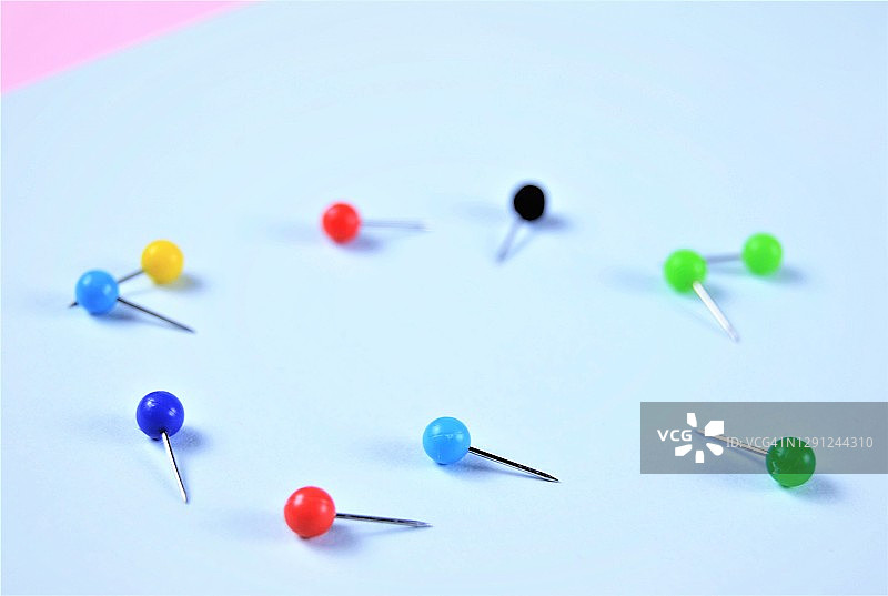 蓝粉背景上的彩色图钉图片素材