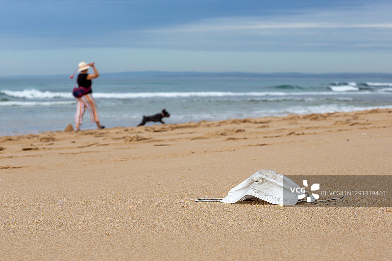 留在海滩上的新冠外科口罩图片素材