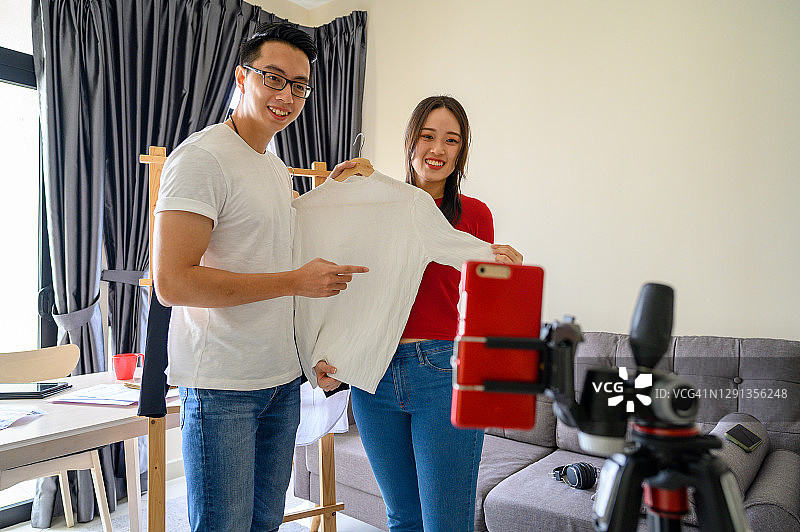 年轻情侣博主在家直播测评产品图片素材