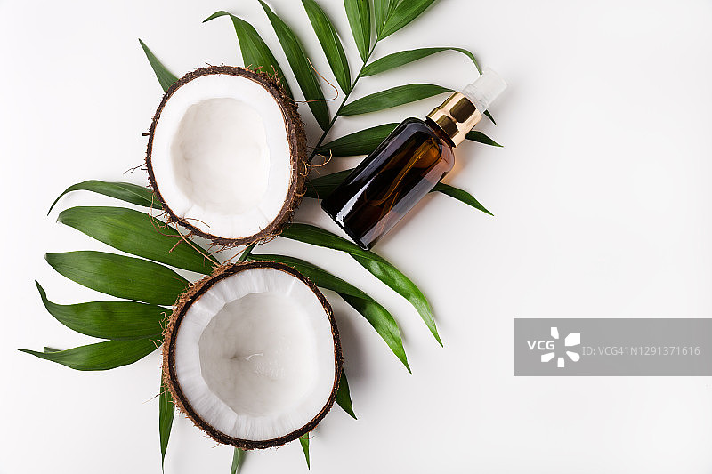 白色背景上的椰子油和新鲜椰子图片素材