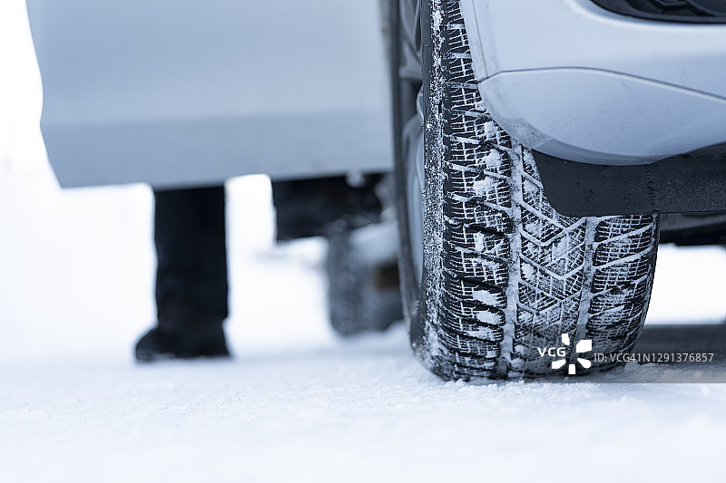 男人在雪地里更换冬季轮胎后下车图片素材