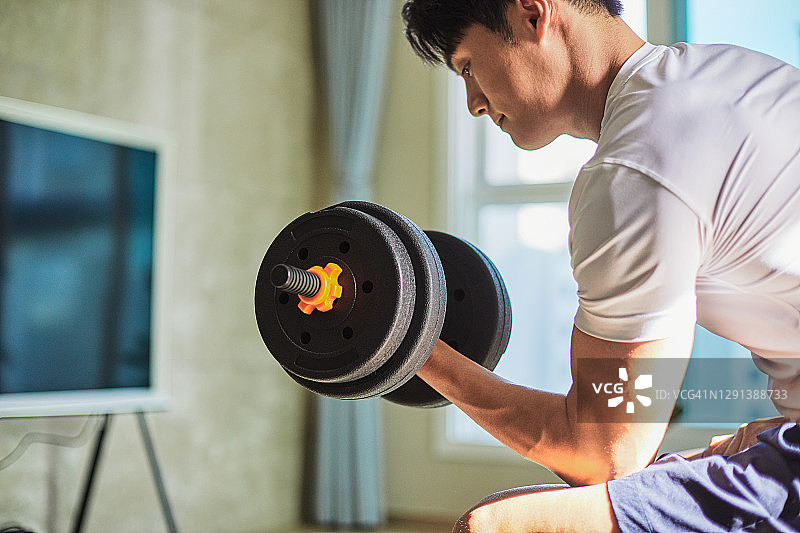 男人在家举哑铃图片素材