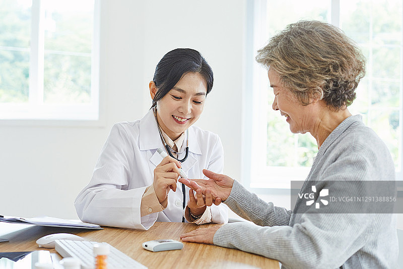 女医生为老年患者测量血糖图片素材