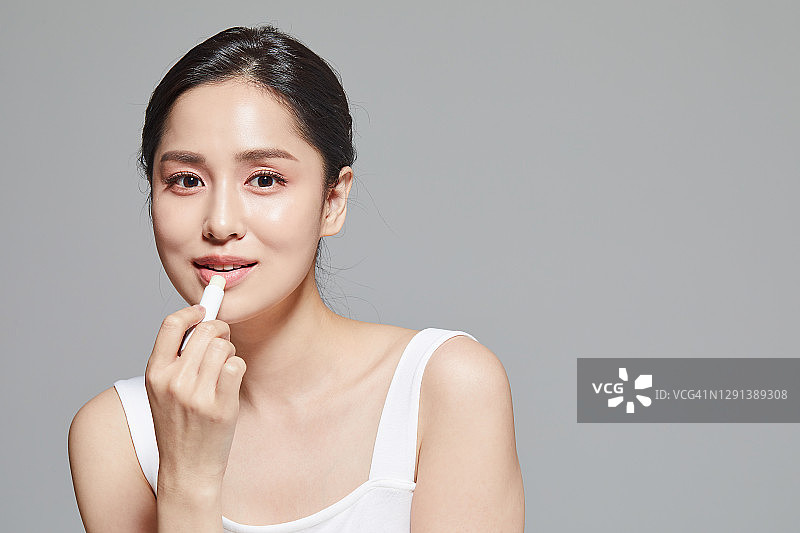 女子涂抹润唇膏图片素材