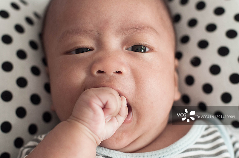 正在吸吮手的东南亚婴儿图片素材