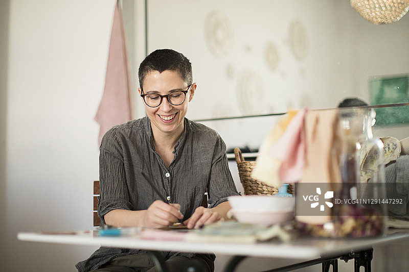 在家中客厅工作的微笑女人图片素材