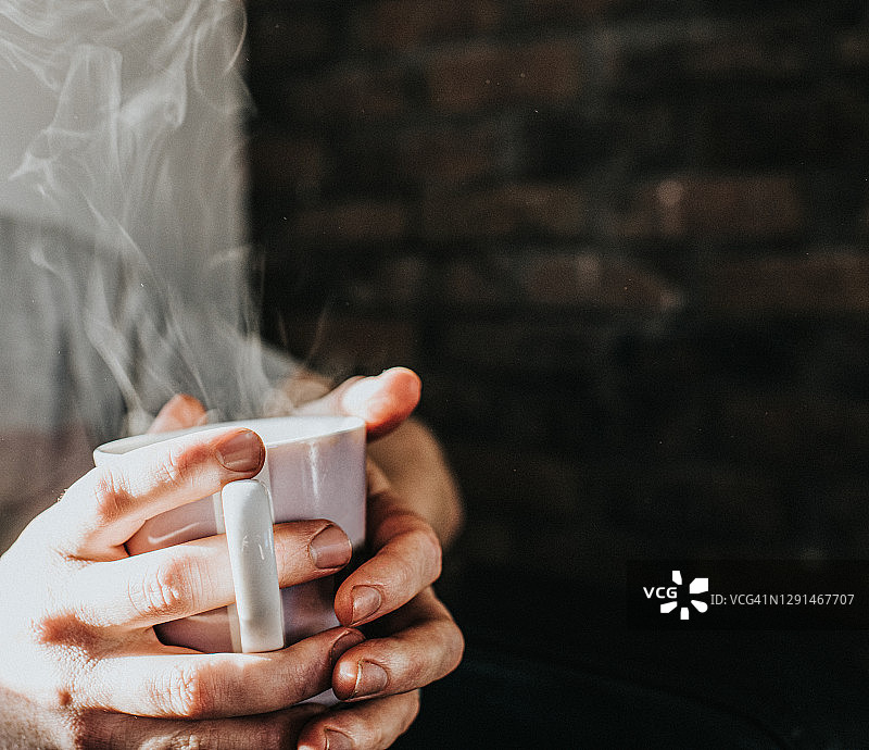 手握热气腾腾的咖啡杯图片素材