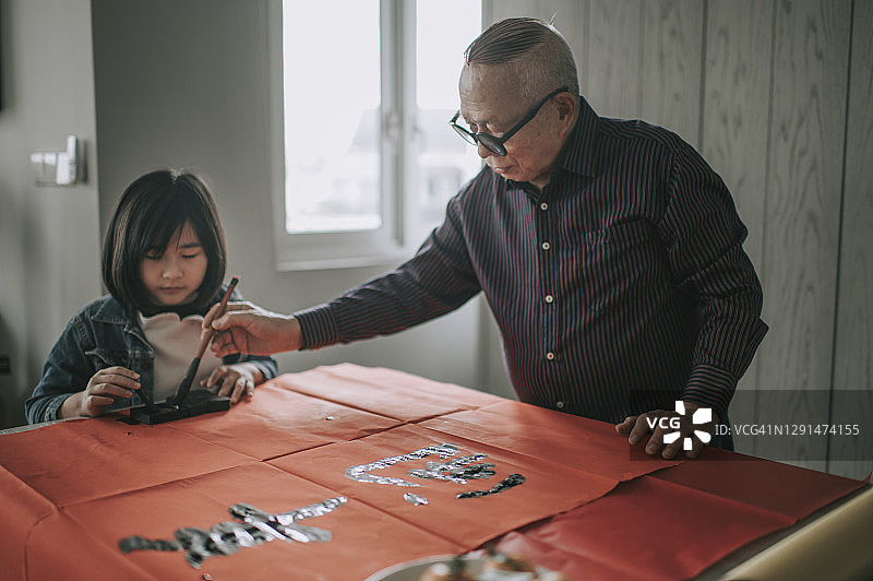 华人小女孩跟爷爷学习中国书法图片素材