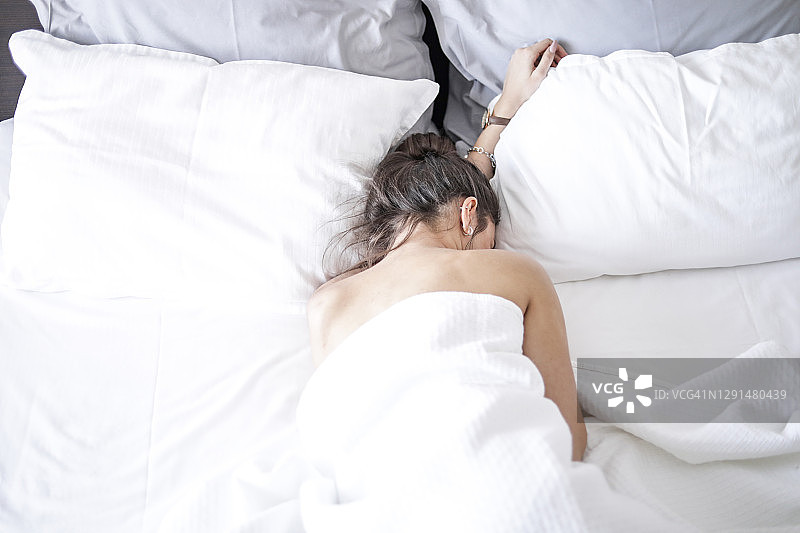 年轻女士在床上享受周末时光图片素材