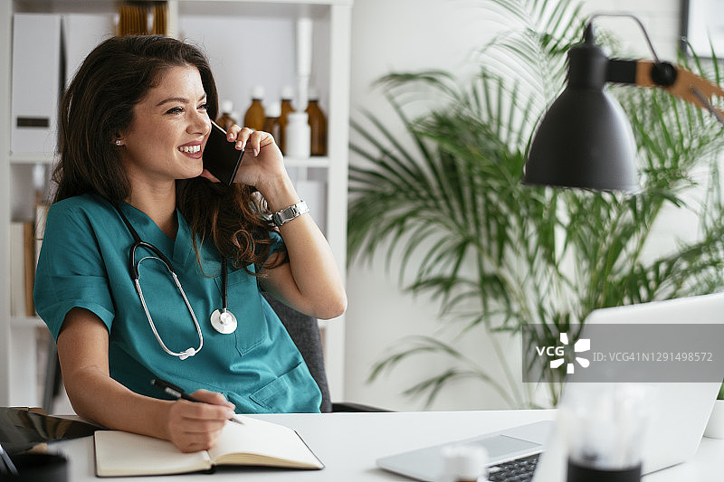 在医疗办公室里打电话的女医生图片素材