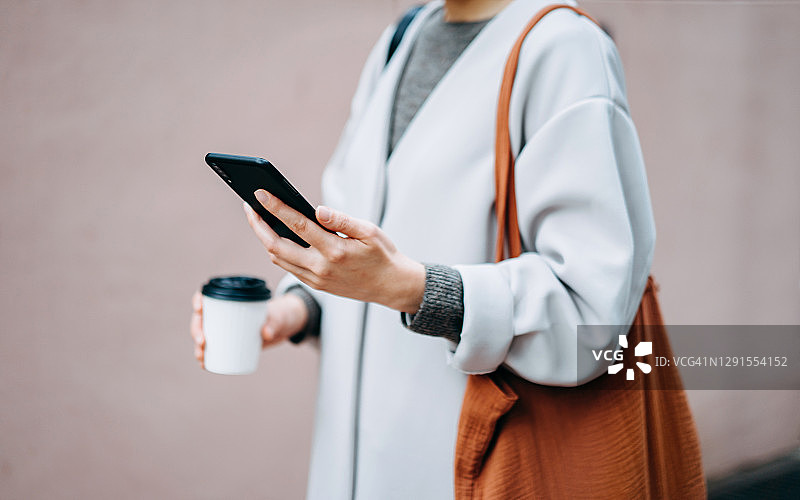 时尚年轻的亚洲女性在城市里喝咖啡图片素材