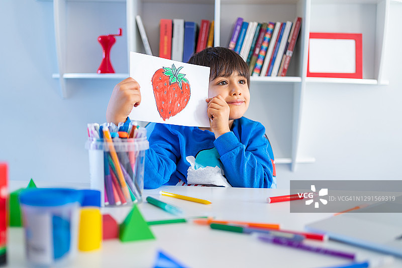 学龄前男童在家中客厅通过视频会议与老师交流绘画作品，进行线上学习图片素材