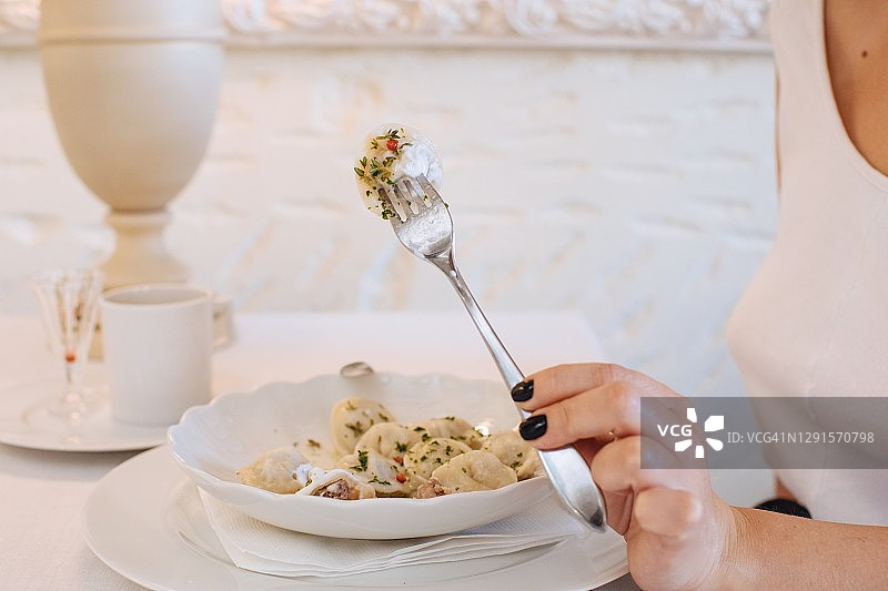 女人在餐厅里吃俄式饺子图片素材