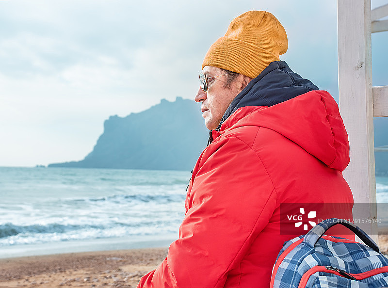 坐在海边的男旅行者肖像图片素材