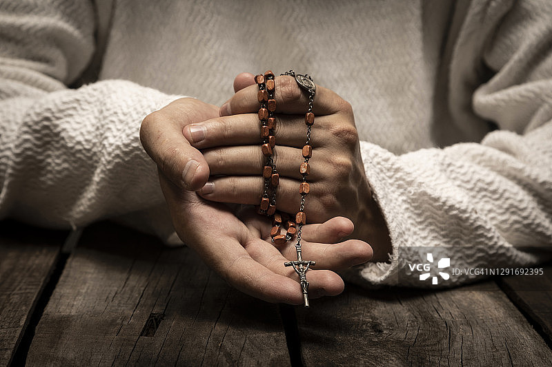 手持圣玫瑰念珠向神祈祷的耶稣基督图片素材