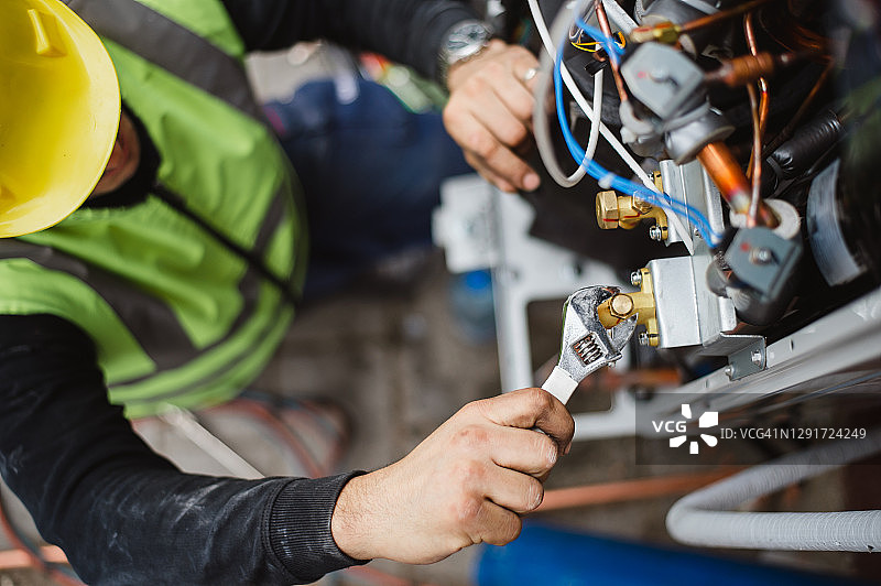 空调技术人员维修室外空调机组和燃气发电机图片素材