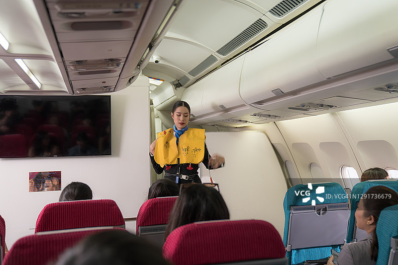 空乘人员在飞机客舱内向乘客演示飞行前安全须知图片素材