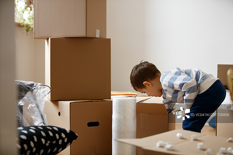 男孩在纸箱里翻找填充泡沫粒图片素材