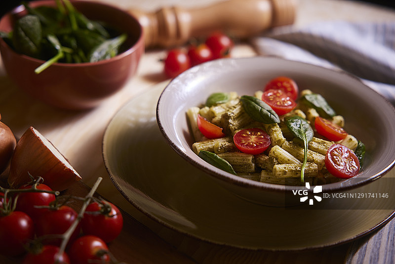 碗中盛放的香蒜酱意面，配樱桃番茄和罗勒图片素材