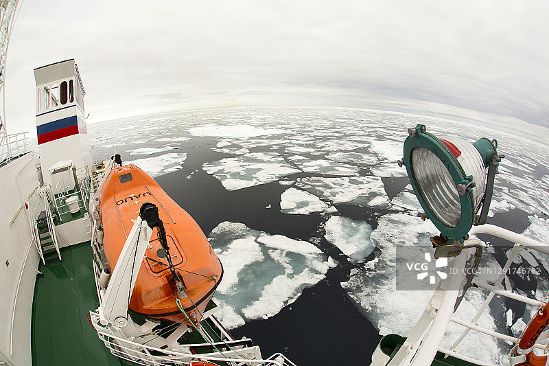 一艘冰层加固船在北极圈以北80多度的斯瓦尔巴特群岛进行探险巡游，周围是融化的海冰，距离北极约550英里图片素材