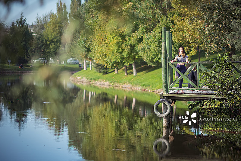 年轻女人在河边享受阳光图片素材