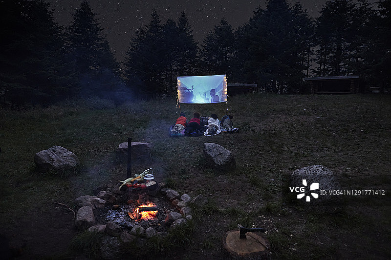 朋友们在晚上观看屏幕上的视频图片素材