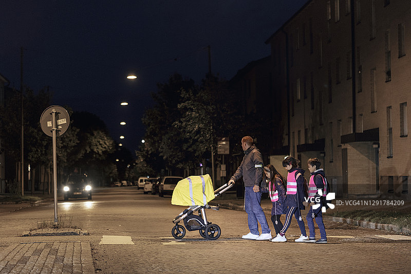 傍晚，父亲带孩子过马路图片素材