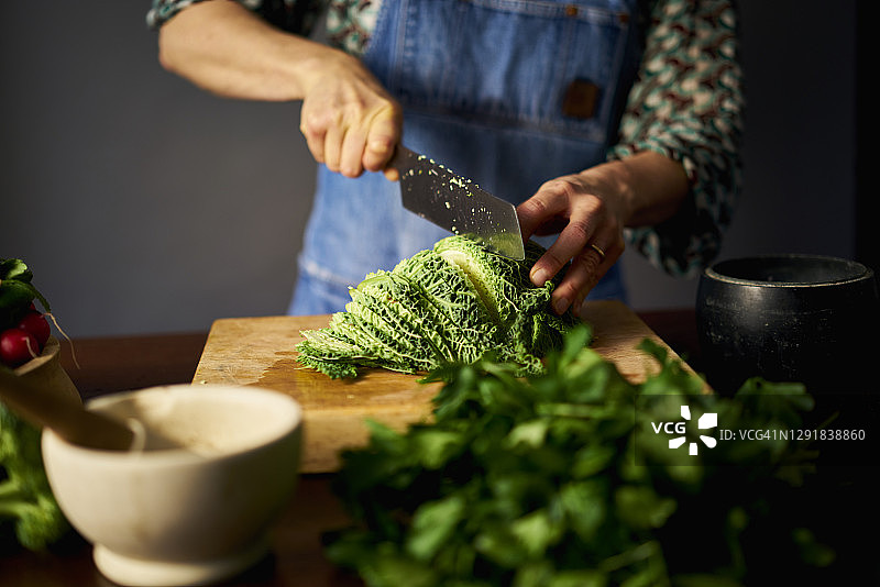 在砧板上精细地切萨沃伊卷心菜图片素材