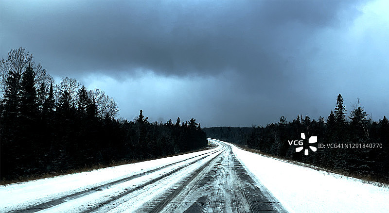 冬季雪天行驶在路上，从车窗向外看图片素材