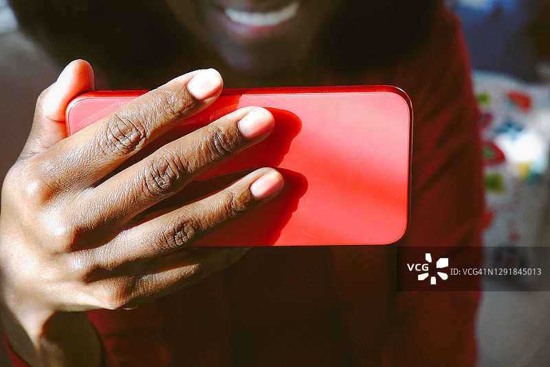 女人在智能手机上进行视频通话时微笑图片素材