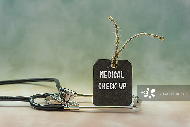 带有黑色标签的听诊器，写着体检，医疗概念和背景图片素材