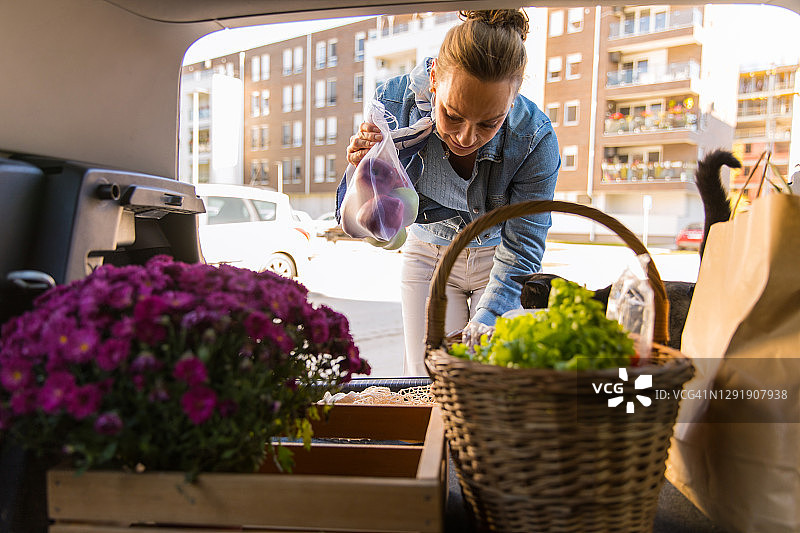 将农贸市场的食品杂货放入汽车后备箱图片素材