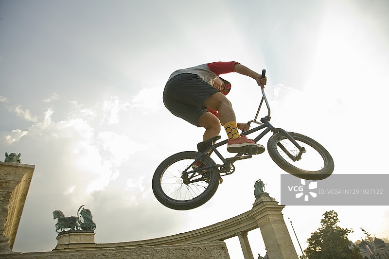 年轻男子在匈牙利布达佩斯英雄广场的BMX自行车上表演特技图片素材